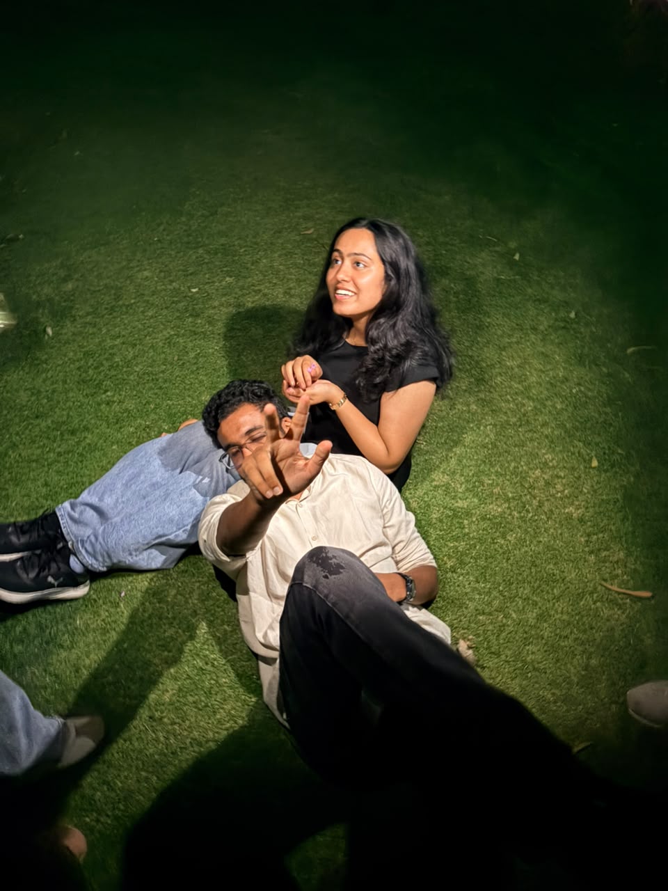 The couple laughing on the grass at night